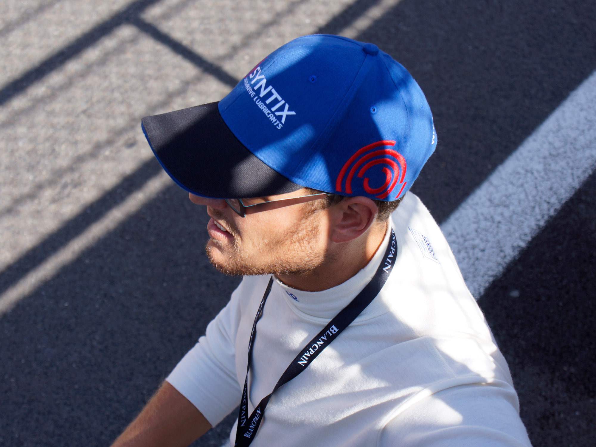 Dark blue Syntix-branded hat featuring the logo and red emblem on the side