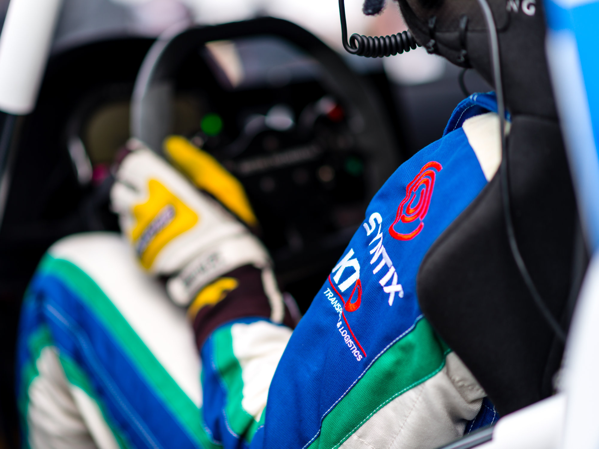 Syntix logo printed on a race driver’s suit, symbolizing sponsorship and performance partnership
