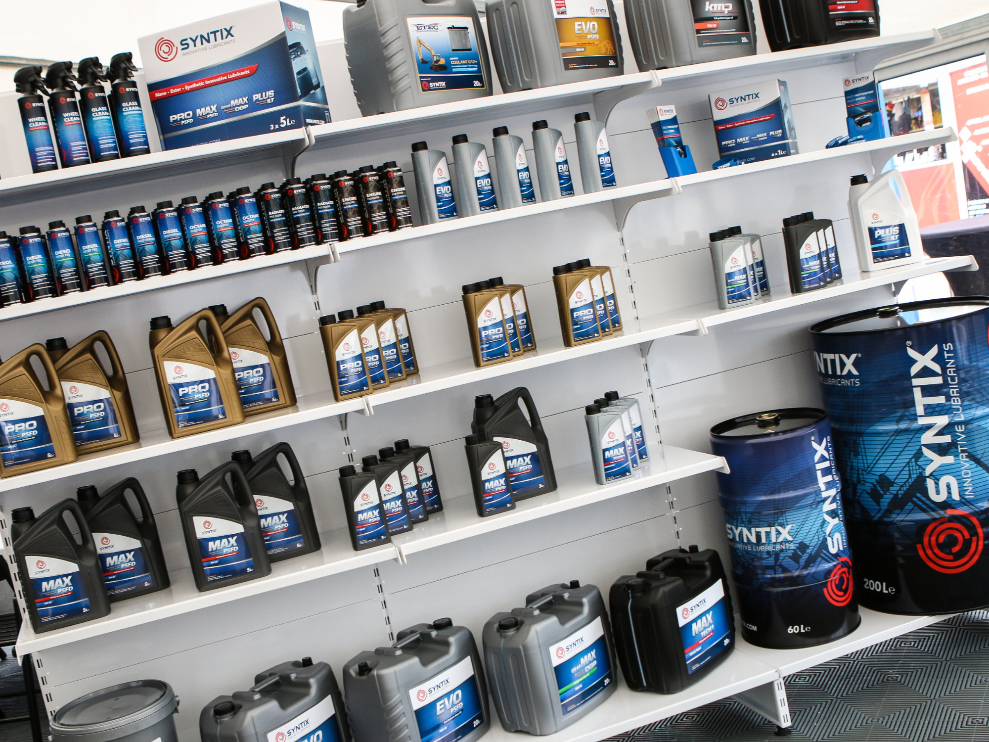 Syntix motor oil bottles and boxes neatly arranged on retail shelves, showcasing branded packaging